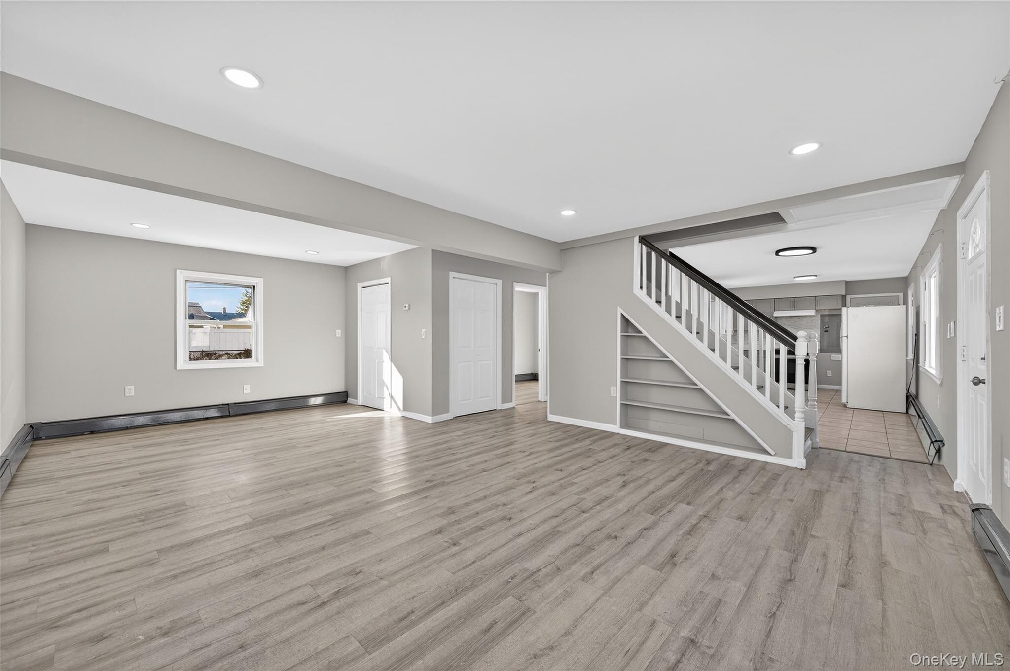 28 Candle Lane Levittown, NY 11756 - Photo 3 of 18 a view of an empty room with wooden floor and stairs