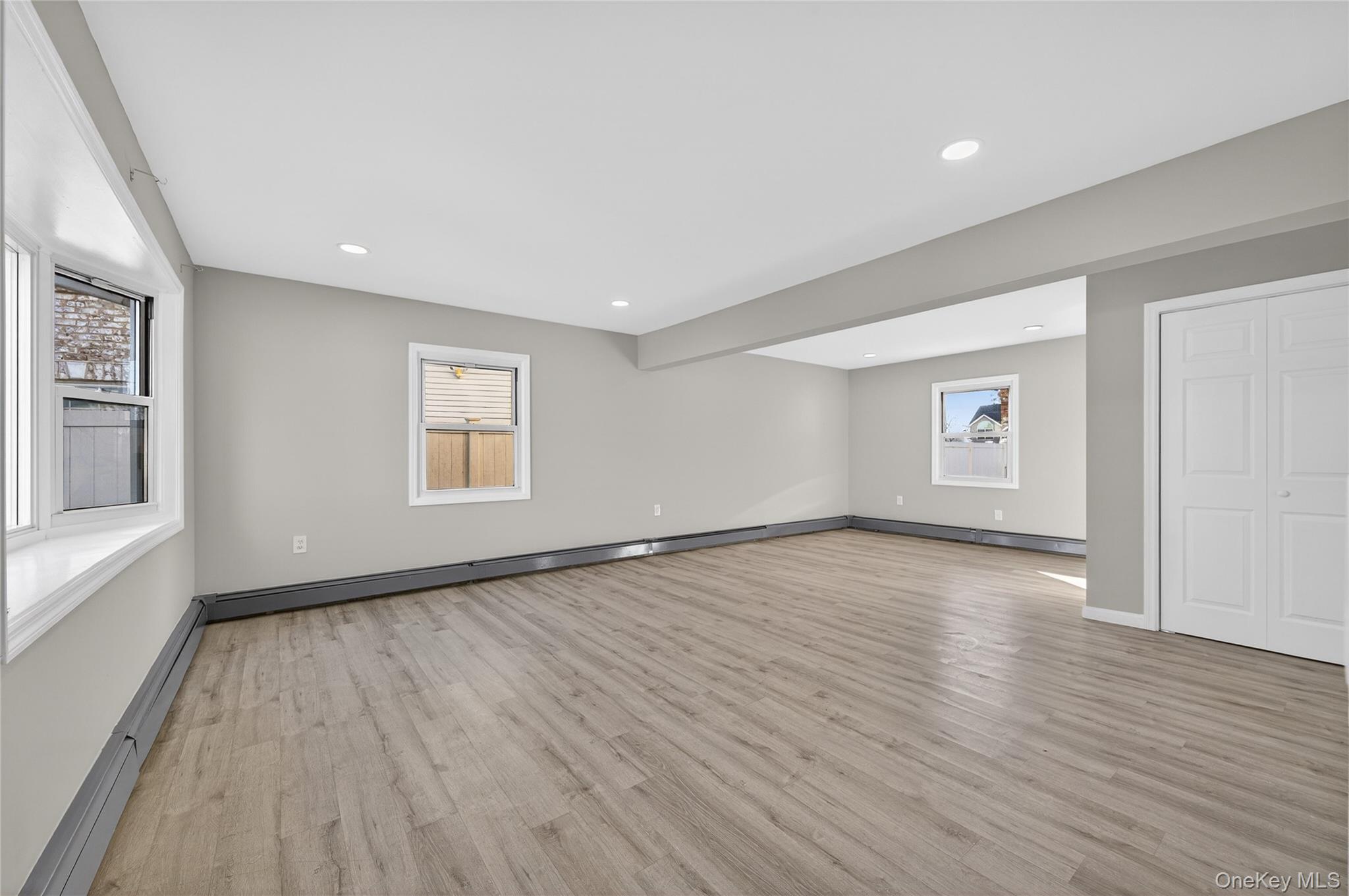 28 Candle Lane Levittown, NY 11756 - Photo 4 of 18 an empty room with wooden floor and windows