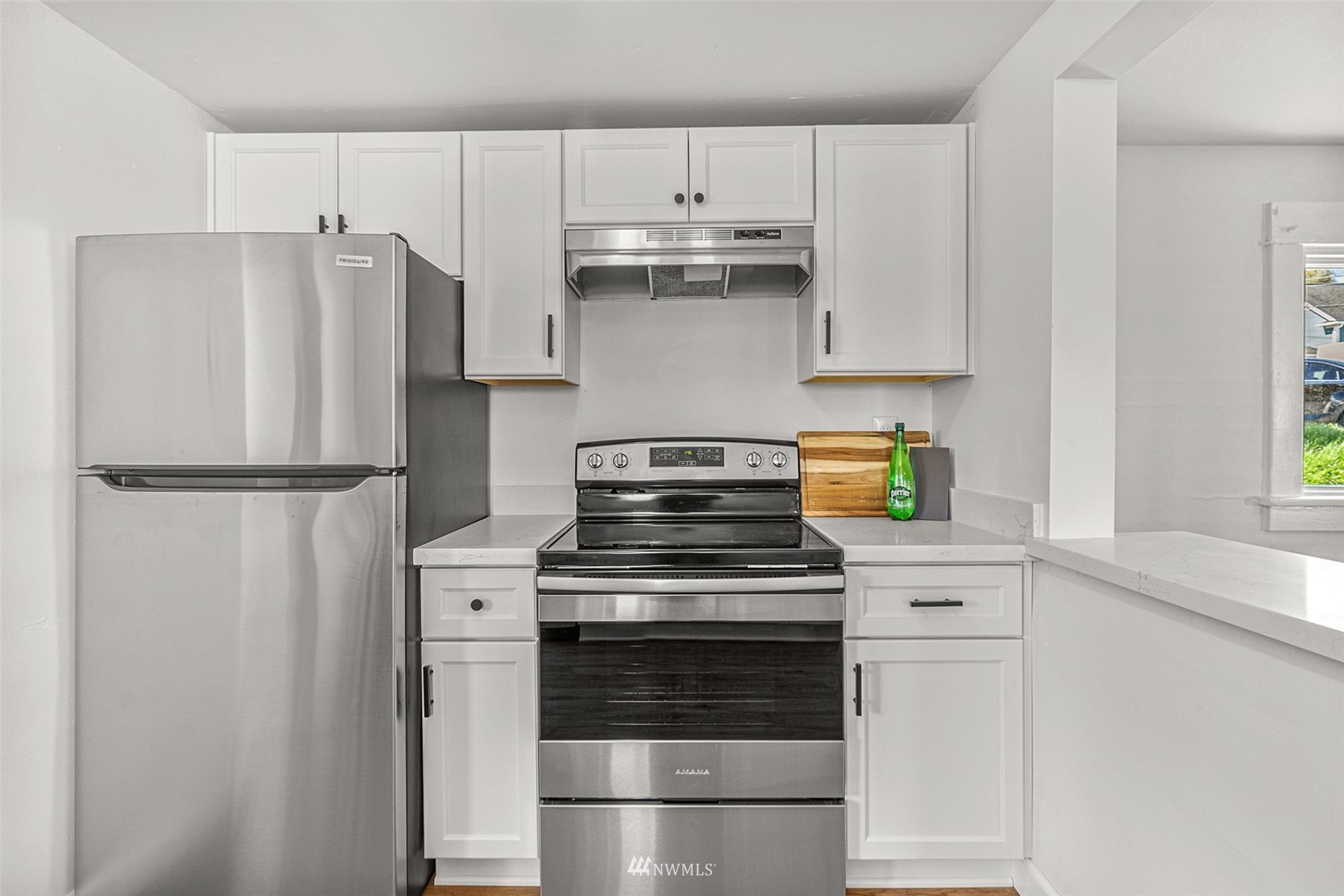 2228 Main Street Everett, WA 98203 - Photo 22 of 29 a kitchen with refrigerator a stove and white cabinets