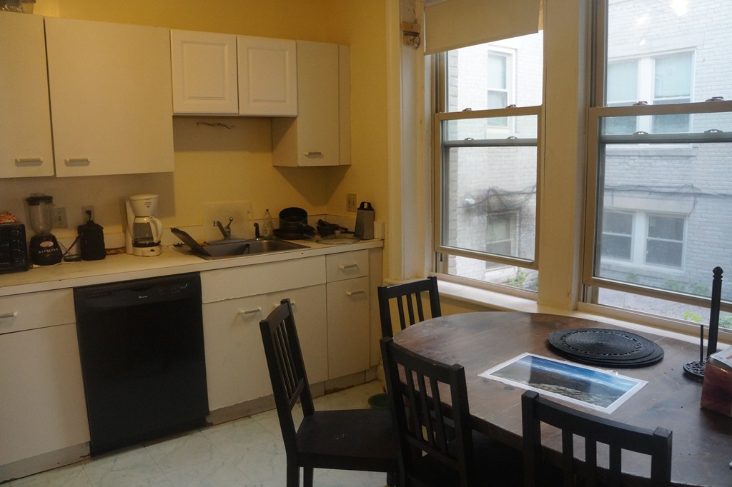 28 Ransom Road, Unit 4 Boston, MA 02135 - Photo 8 of 9 a kitchen with a table chairs and cabinets