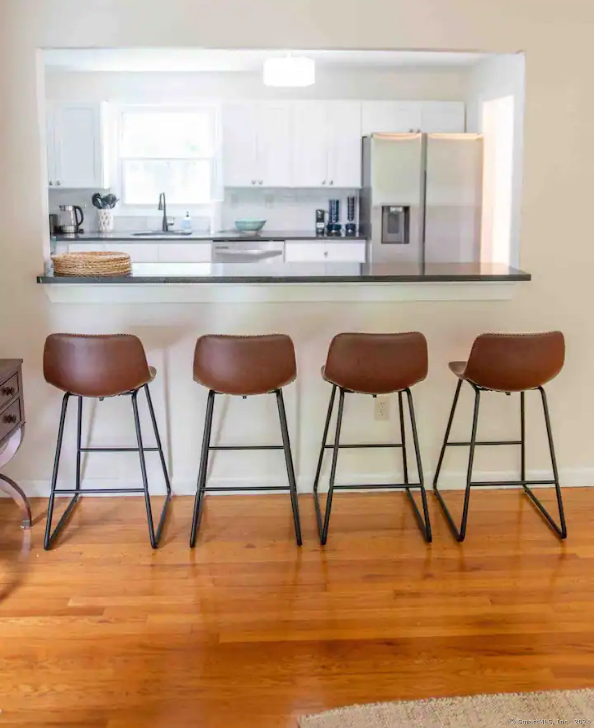 a kitchen with stainless steel appliances kitchen island a table chairs in it and wooden floor