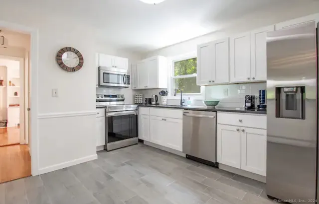 a kitchen with white cabinets and white appliances