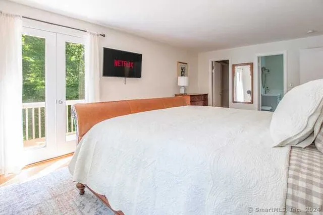 a bedroom with a bed wooden floor and window