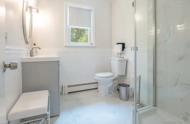 a bathroom with a toilet sink and mirror