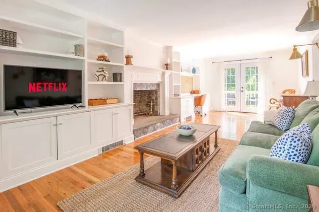 a living room with furniture a flat screen tv and a floor to ceiling window