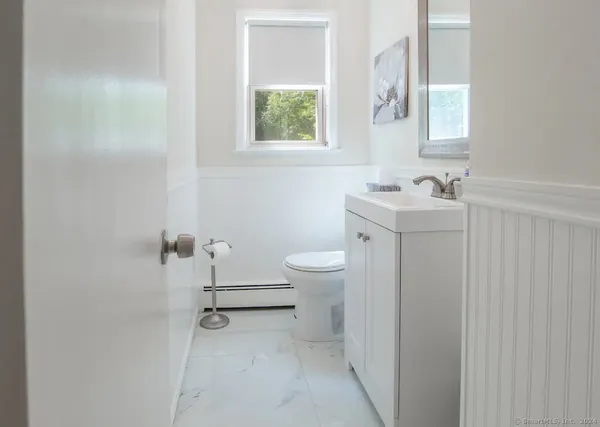 a bathroom with a sink a toilet and a window