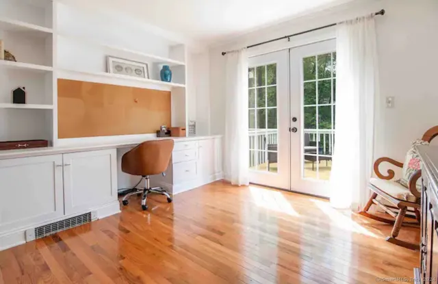 a view of a workspace with furniture and a window