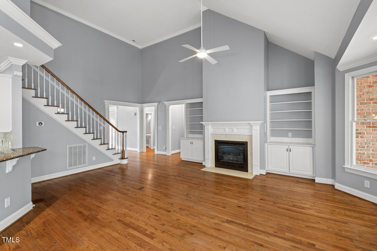 5900 Orchid Valley Road Raleigh, NC 27613 - Photo 12 of 52 a view of an empty room with wooden floor fireplace and a window