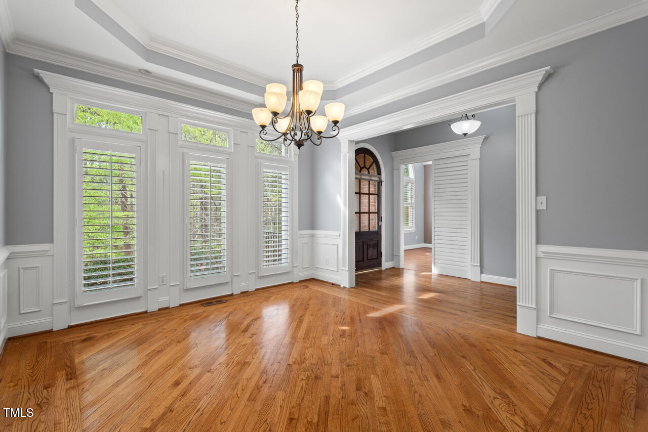 5900 Orchid Valley Road Raleigh, NC 27613 - Photo 7 of 52 an empty room with wooden floor chandelier and windows