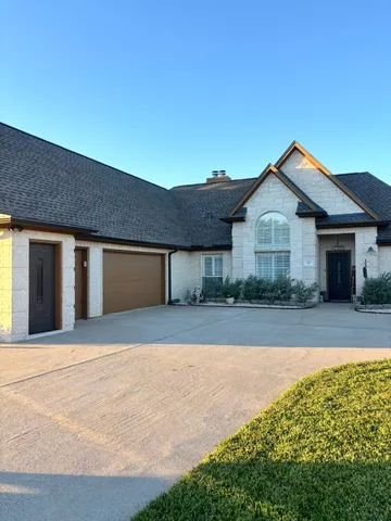 a front view of house with yard and trees in the background