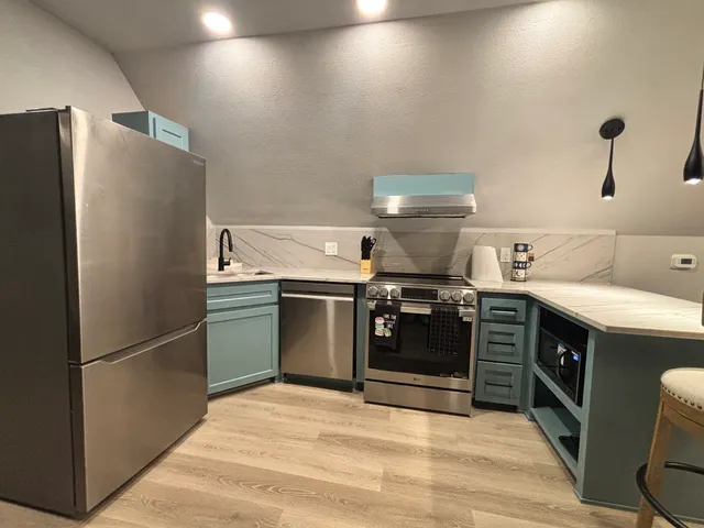 a kitchen with stainless steel appliances granite countertop a refrigerator and a stove
