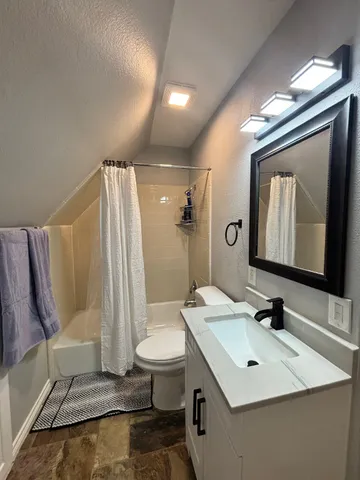 a bathroom with a sink vanity mirror and toilet