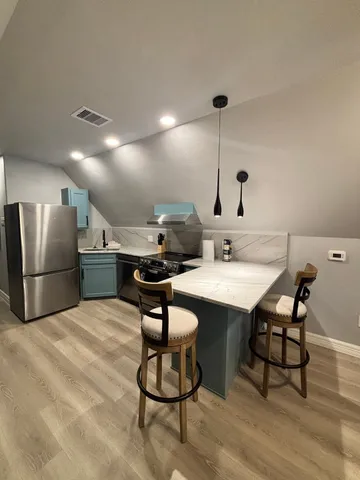 a kitchen with stainless steel appliances a sink and a refrigerator