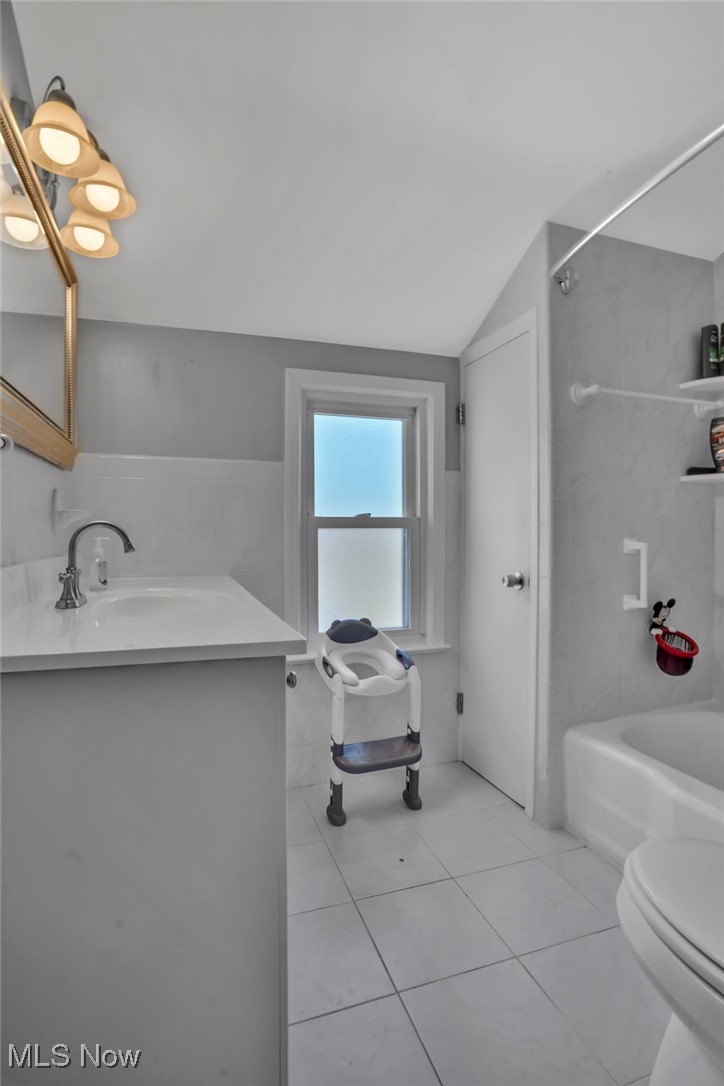 5265 East Farnhurst Road Cleveland, OH 44124 - Photo 17 of 28 Bathroom with toilet, tile patterned floors, vanity, lofted ceiling, and shower / bathtub combination