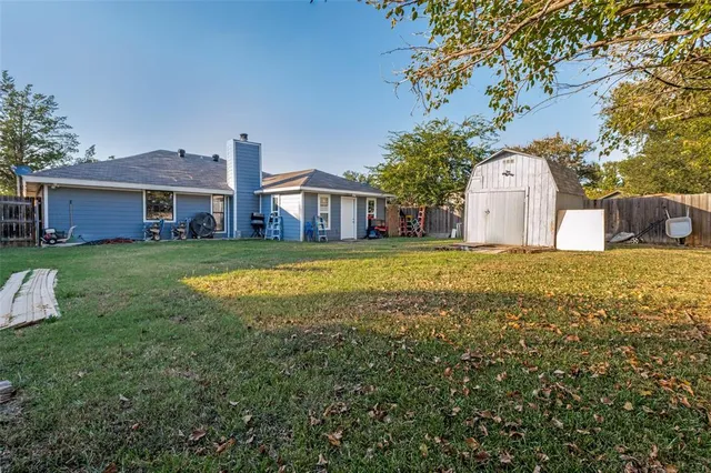 a view of a house with a big yard and large trees