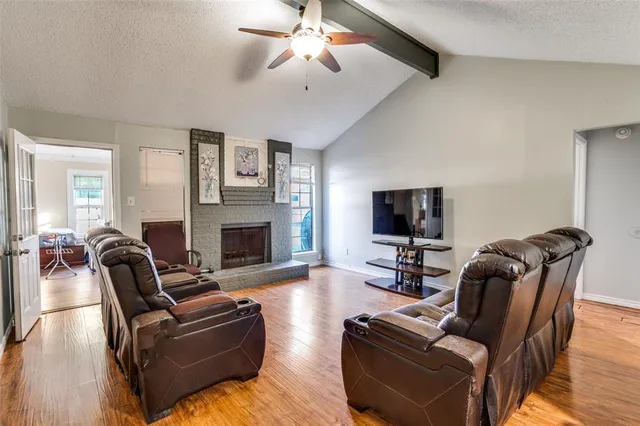 a living room with furniture a flat screen tv and a fireplace