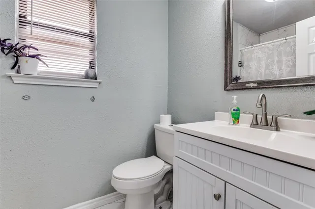a bathroom with a sink a toilet and a mirror