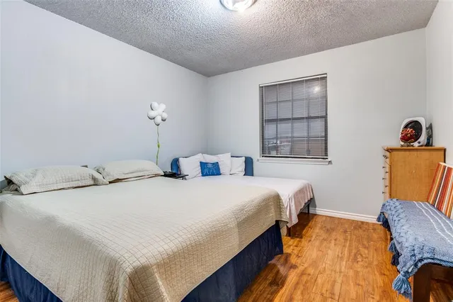 a bedroom with bed and wooden floor