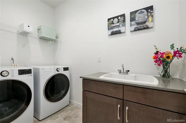 a utility room with sink dryer and washer