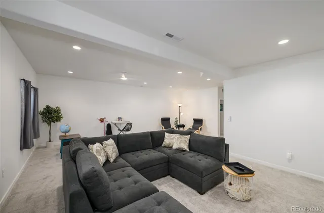 a living room with furniture and a potted plant