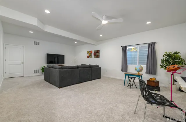 a living room with furniture a flat screen tv and a large window
