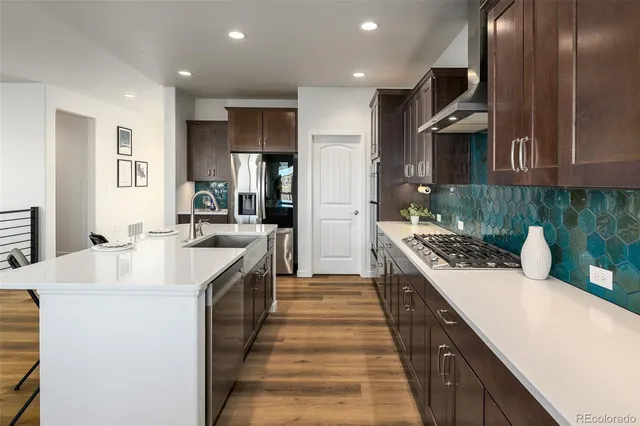 a kitchen with stainless steel appliances a sink stove and refrigerator