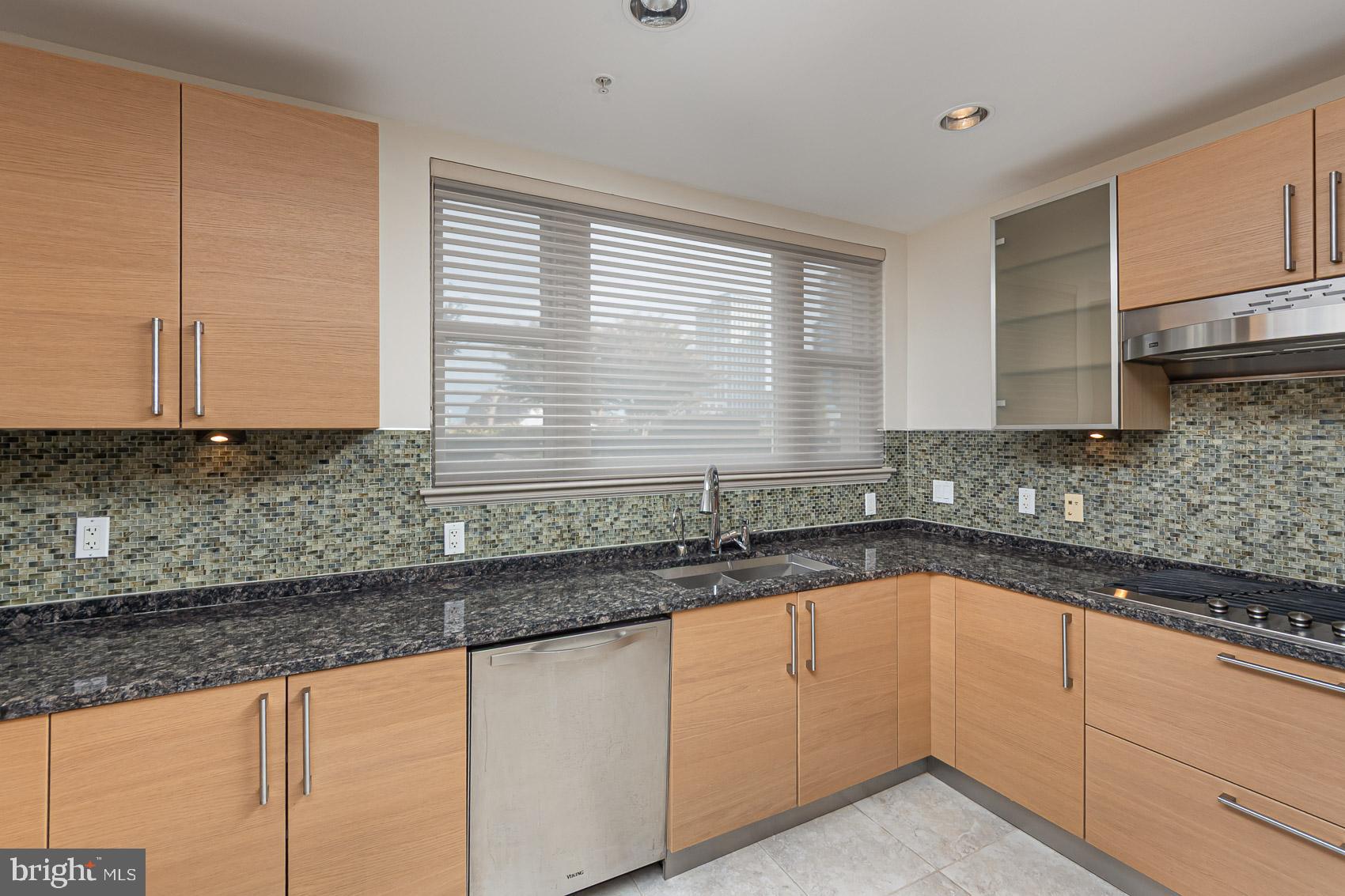 801 Key Highway, Unit 153 Baltimore, MD 21230 - Photo 3 of 40 a kitchen with granite countertop a sink and a white cabinets