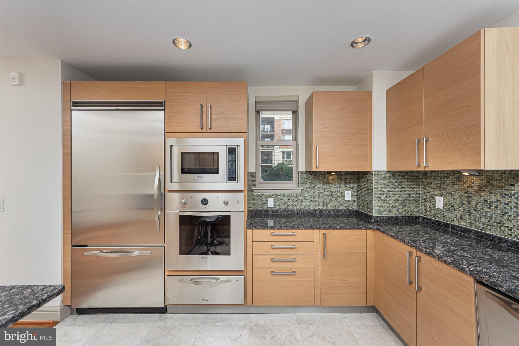 801 Key Highway, Unit 153 Baltimore, MD 21230 - Photo 7 of 40 a kitchen with granite countertop white cabinets and stainless steel appliances