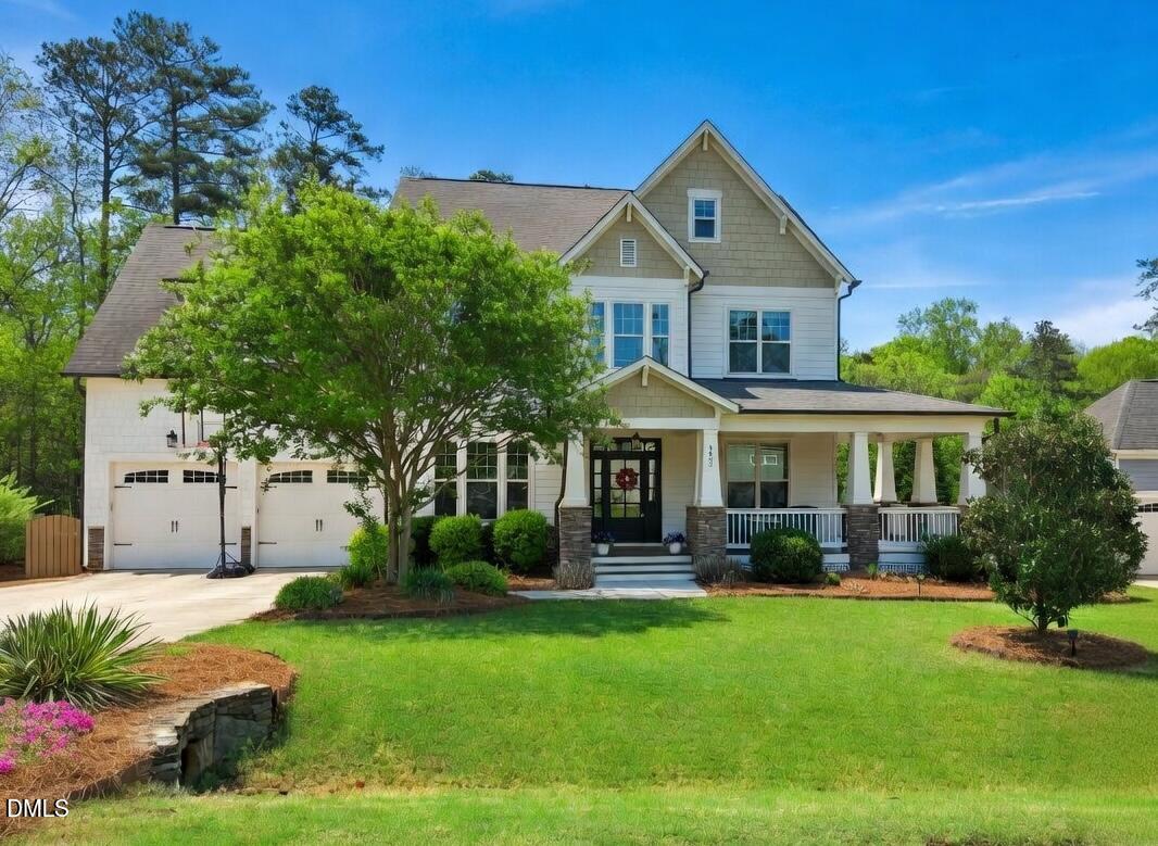 a front view of a house with a yard and potted plants