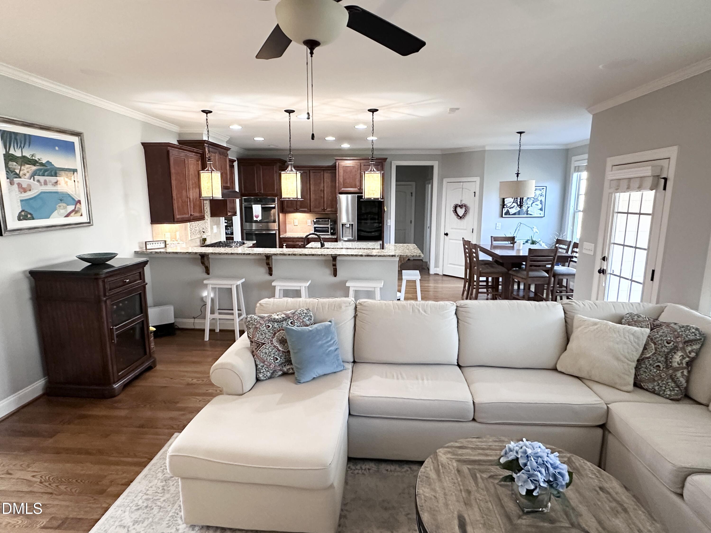 4603 Brighton Ridge Drive Apex, NC 27539 - Photo 16 of 69 a living room with furniture kitchen view and a chandelier