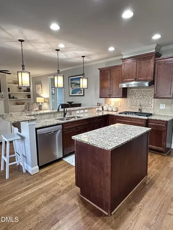 a kitchen with stainless steel appliances granite countertop a stove refrigerator and cabinets