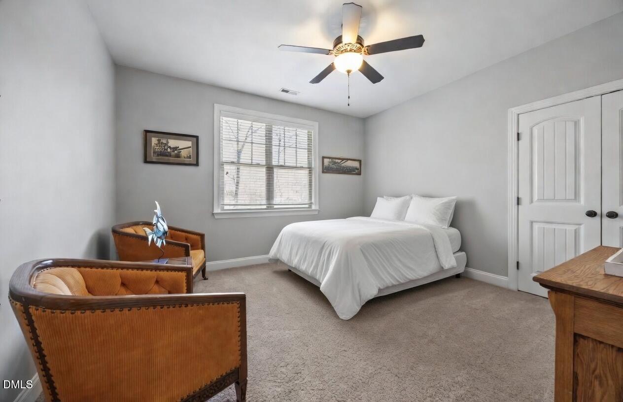 4603 Brighton Ridge Drive Apex, NC 27539 - Photo 31 of 69 a bedroom with a bed and a chandelier