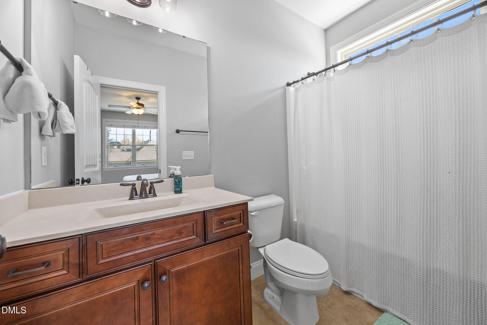 4603 Brighton Ridge Drive Apex, NC 27539 - Photo 35 of 69 a bathroom with a sink a toilet a mirror and shower curtain