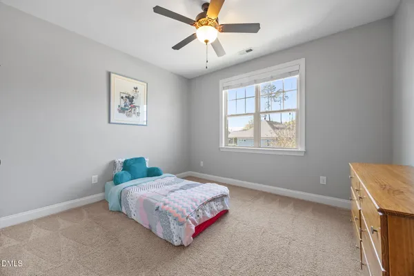a bedroom with a bed chair and a large window