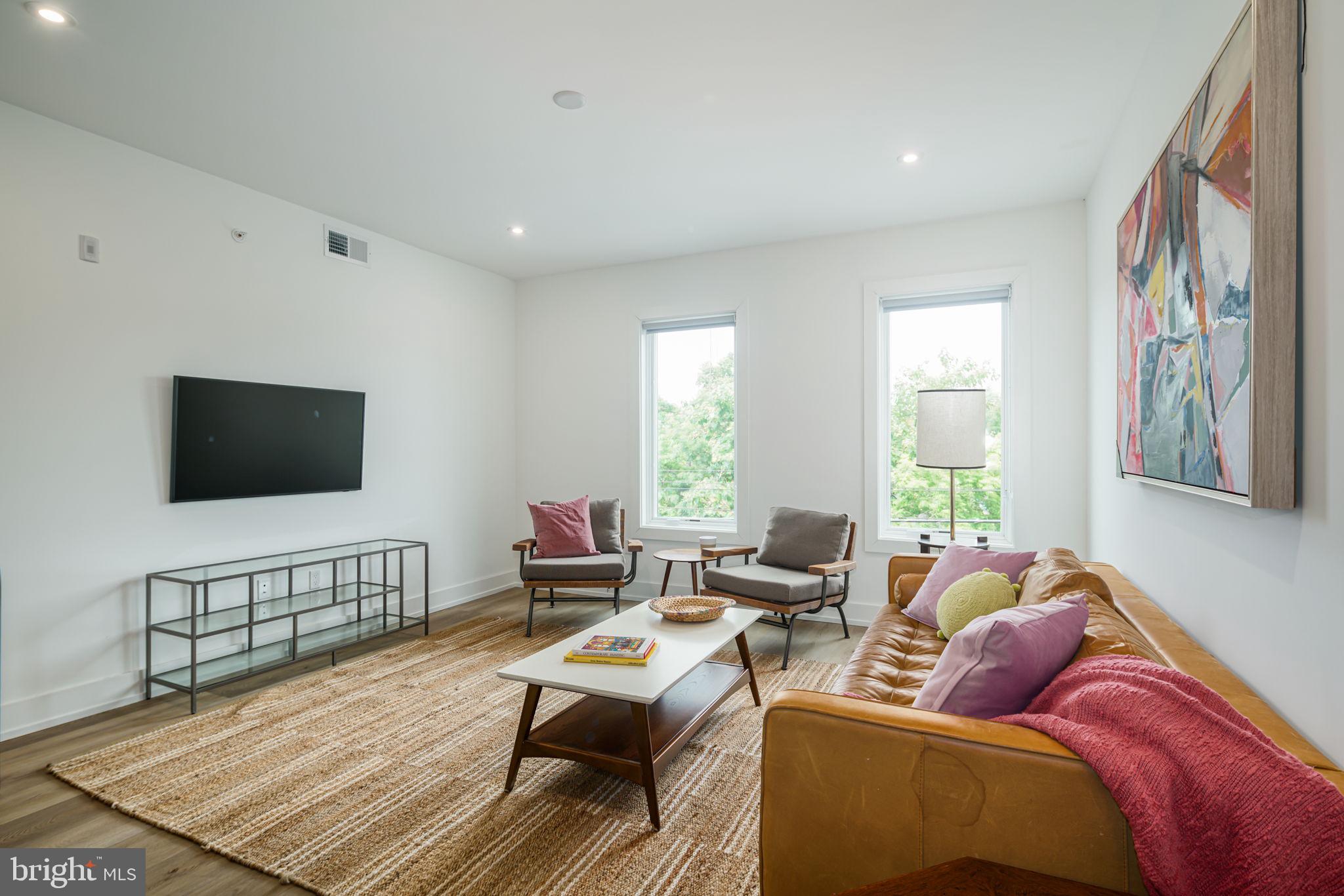 5013 Springfield Avenue, Unit 406 Philadelphia, PA 19143 - Photo 2 of 17 a living room with furniture and a flat screen tv