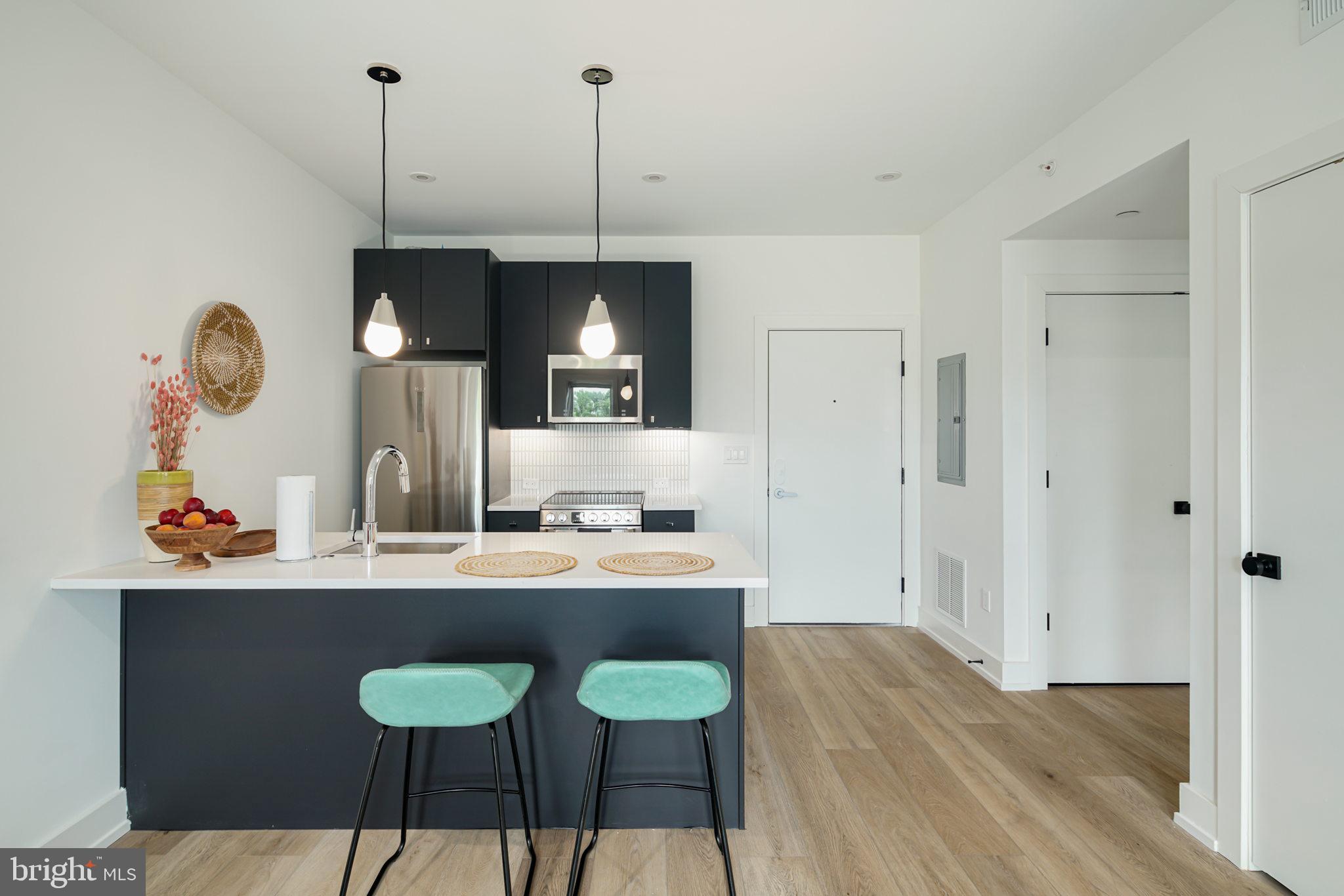 5013 Springfield Avenue, Unit 406 Philadelphia, PA 19143 - Photo 5 of 17 a kitchen with a table and chairs in it