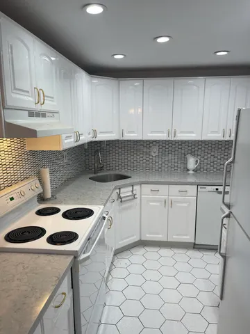a kitchen with a sink a stove cabinets and counter space