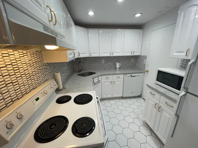 a kitchen with a sink a stove and cabinets