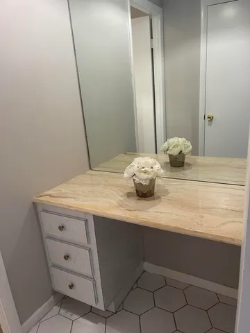 a bathroom with a granite countertop sink and a mirror