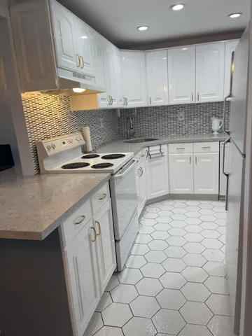 a kitchen with stainless steel appliances granite countertop a sink stove and cabinets
