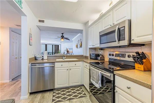 a kitchen with stainless steel appliances granite countertop a refrigerator sink and stove