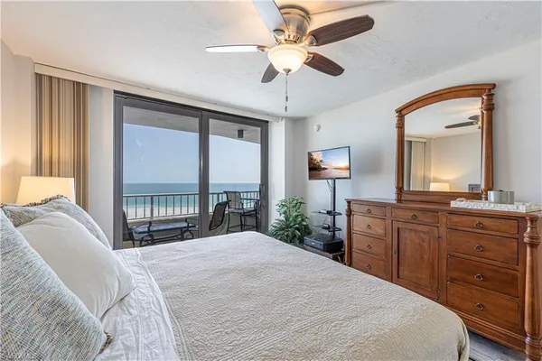 a bedroom with a large bed and a chandelier