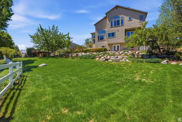 12317 Cypress Point Way Draper, UT 84020 - Photo 36 of 41 Expansive rear yard featuring a verdant lawn and a decorative white fence