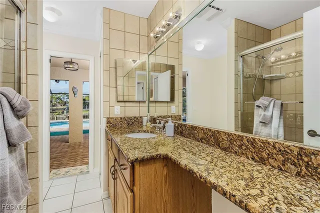 a bathroom with a granite countertop shower sink and mirror