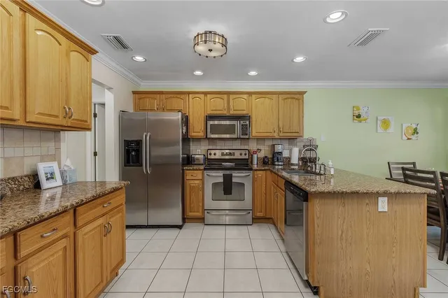 a kitchen with stainless steel appliances granite countertop a refrigerator and a stove top oven