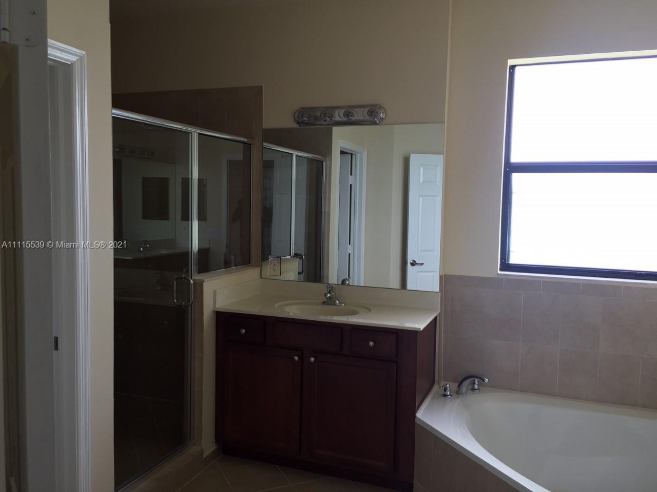 8630 West 33rd Avenue Hialeah, FL 33018 - Photo 21 of 22 a bathroom with a granite countertop sink and a bathtub