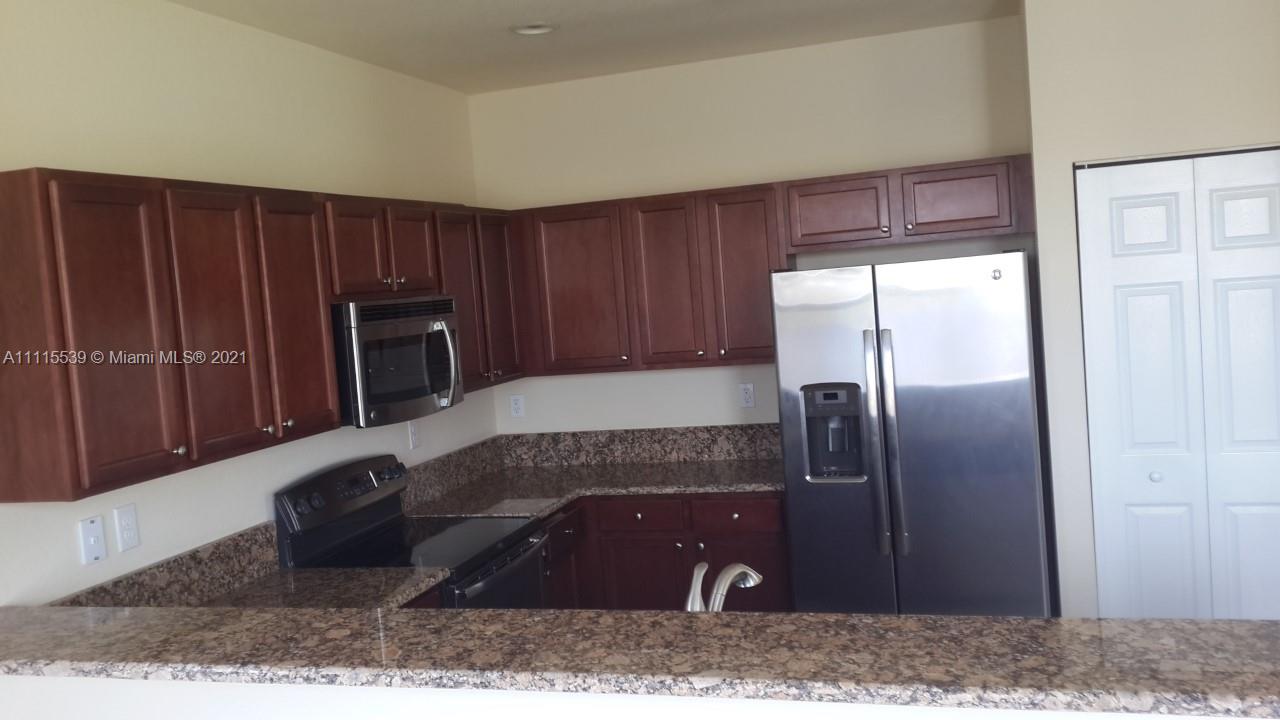 8630 West 33rd Avenue Hialeah, FL 33018 - Photo 4 of 22 a kitchen with granite countertop a refrigerator and a sink