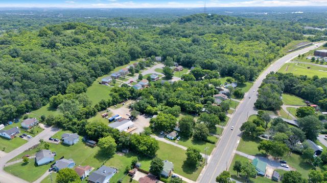 an aerial view of residential house with outdoor space and trees