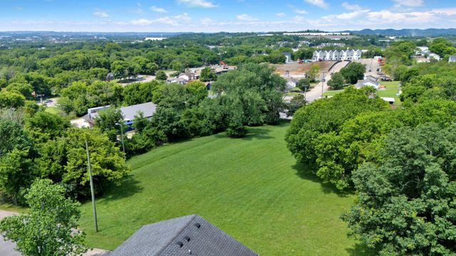a view of a lush green forest with a house