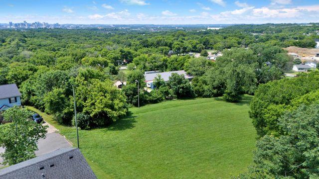 a view of a lush green forest with trees and some houses